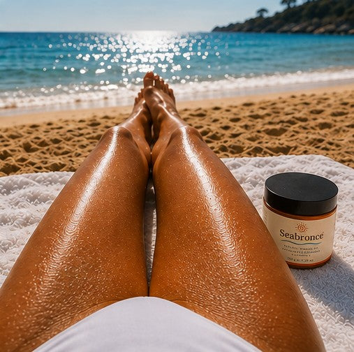 Piernas bronceadas en la playa junto al bote de Seabronce