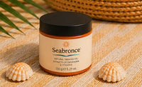 Bote de Seabronce cerrado, con conchas y estrella de mar en la playa