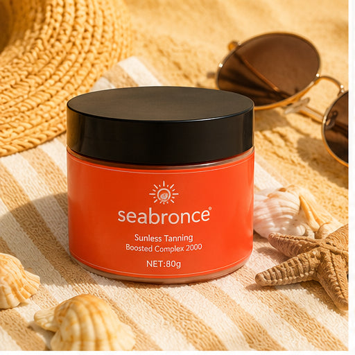 Bote de Seabronce cerrado sobre toalla de playa con sombrero y gafas de sol